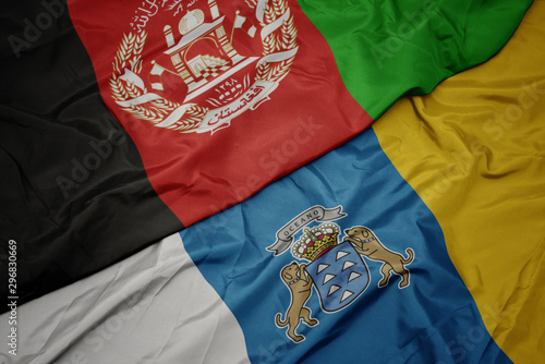 waving colorful flag of canary islands and national flag of afghanistan.
