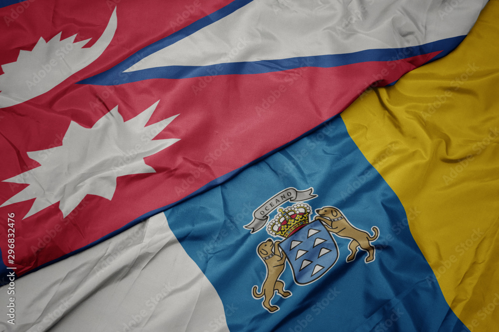 waving colorful flag of canary islands and national flag of nepal. waving colorful flag of canary islands and national flag of nepal.