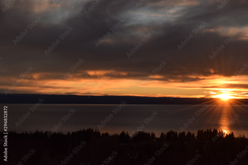 Cold sunrise on the lake, golden sky with clouds