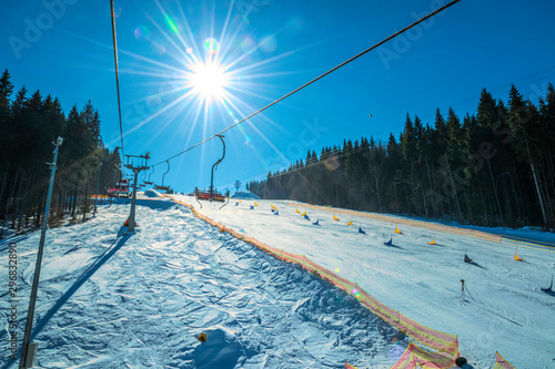 Frosty morning at the ski resort Bukovel. Ski slope and wooden cottages