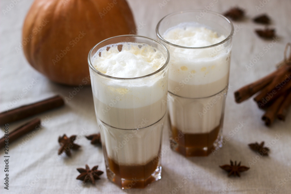 Homemade pumpkin latte in tall glasses and pumpkin on a linen tablecloth. Rustic style. Homemade pumpkin latte in tall glasses and pumpkin on a linen tablecloth. Rustic style.