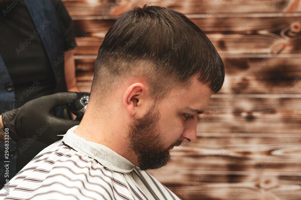 Haircut head in barbershop. Barber cuts the hair on the head of the client. The process of creating hairstyles for men. Barber shop. Selective focus. Haircut head in barbershop. Barber cuts the hair on the head of the client. The process of creating hairstyles for men. Barber shop. Selective focus.