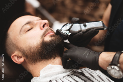 Shaving a beard in a barbershop with a dangerous razor. Barber Shop Beard Care. Drying, cutting, cutting a beard. Selective focus.