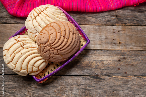 Tableau sur toile Mexican sweet bread: vanilla and chocolate conchas on wooden background