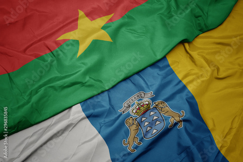 waving colorful flag of canary islands and national flag of burkina faso.
