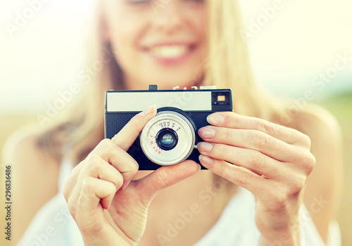 photography, summer holidays, vacation and people concept - close up of young woman taking picture with film camera outdoors
