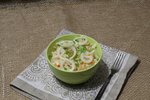 bowl of pickled cabbage with onion on sackcloth background in rustic style