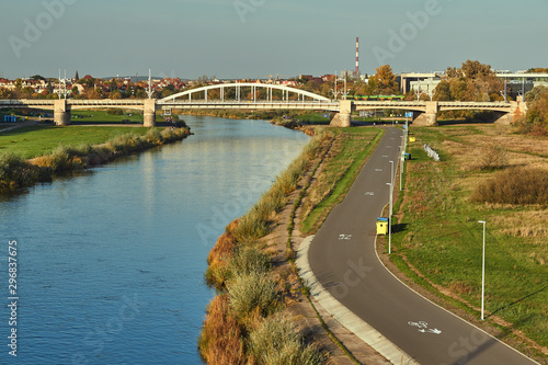 Bicycle path over the Warta river and steel bridge in the city of Poznan.