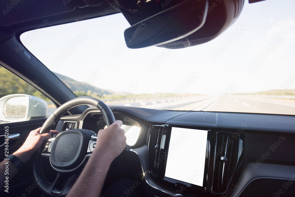 Man driving a car. Success in motion. Handsome young man driving a car. A man holds the steering wheel of a car.