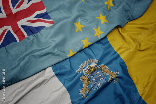 waving colorful flag of canary islands and national flag of Tuvalu .