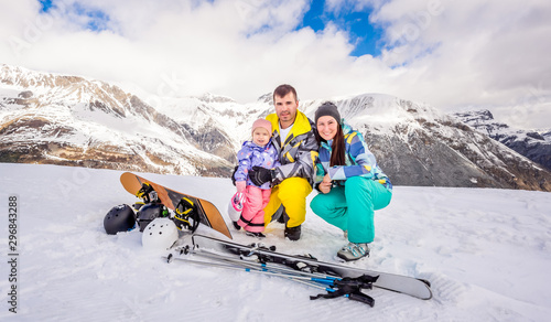 Happy family on ski and snowboard holidays, Livigno, Italy, Alps