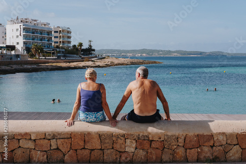 Couple sitting on dock near beach