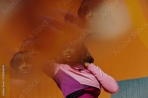 Double exposure of portrait of young woman stretching arms