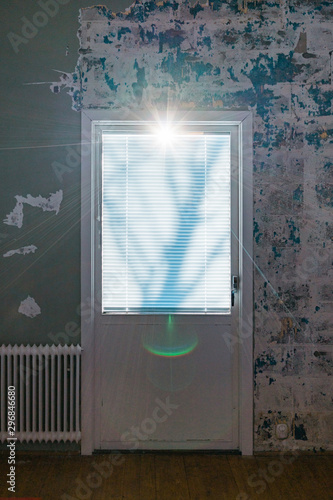 Sunrays passing through window blinds of door