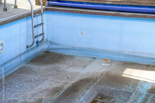 A dirty, abandoned swimming pool without water. Old Swimming Pool Without Wate.