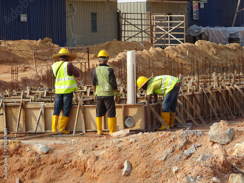 KUALA LUMPUR, MALAYSIA -MARCH, 2019: Construction workers installing & fabricating ground beam timber form works at the construction site. The form works made from timber and plywood. 