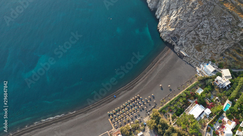 Fototapeta Naklejka Na Ścianę i Meble -  Aerial drone photo of famous seaside village and organised with sun-beds and umbrellas sandy beach of Kamari, Santorini island, Cyclades, Greece