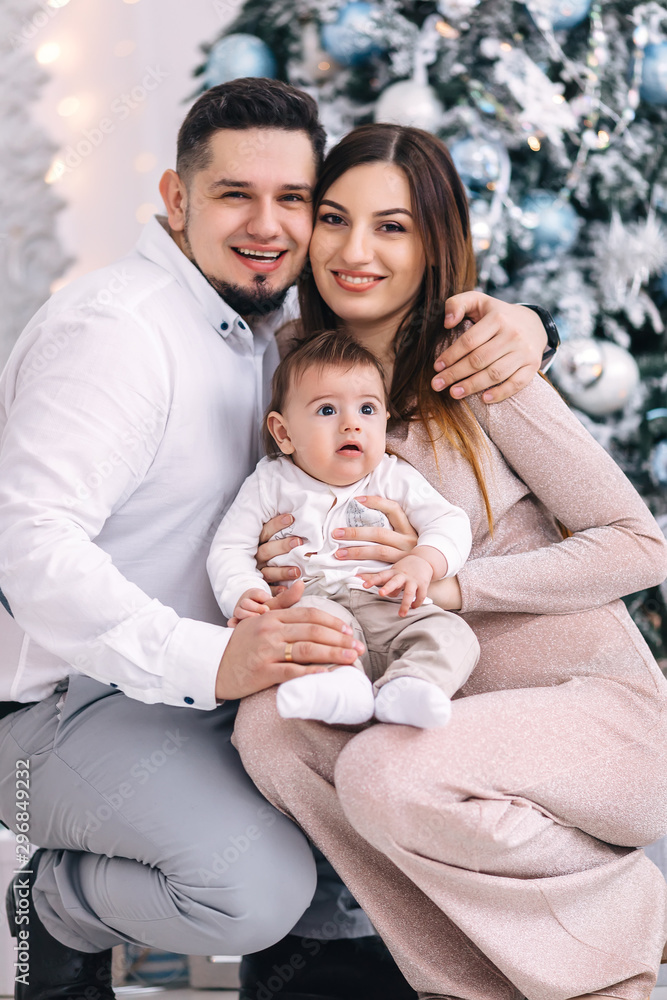 Dad, mom and little son on Christmas tree background. close up. Dad, mom and little son on Christmas tree background. close up.