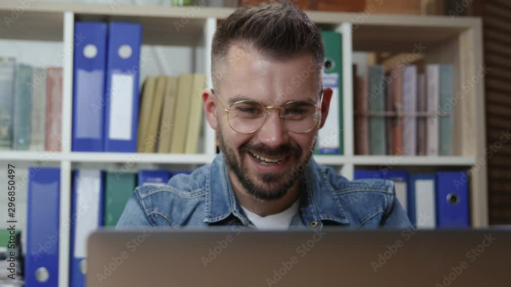 Portrait of ambitious hipster young man business employee working by laptop monitor looking shaking head in approval in modern corporate office. Portrait of ambitious hipster young man business employee working by laptop monitor looking shaking head in approval in modern corporate office.