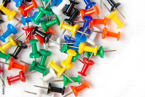 Flat lay top view of many colorful push pins on white background. Office concept..