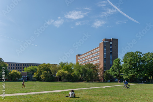 Outdoor sunny view of Innerer Grüngürtel, state park, in front of buildings of University of cologne against blue sky. in Cologne, Germany.