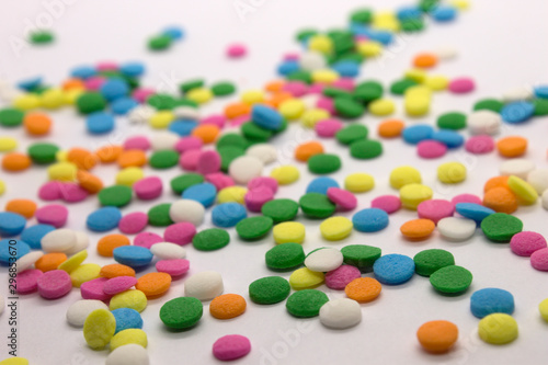 This is a photograph of colorful round sprinkles isolated on a White Background