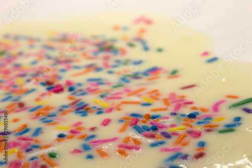This is a photograph of White chocolate topped with colorful sprinkles