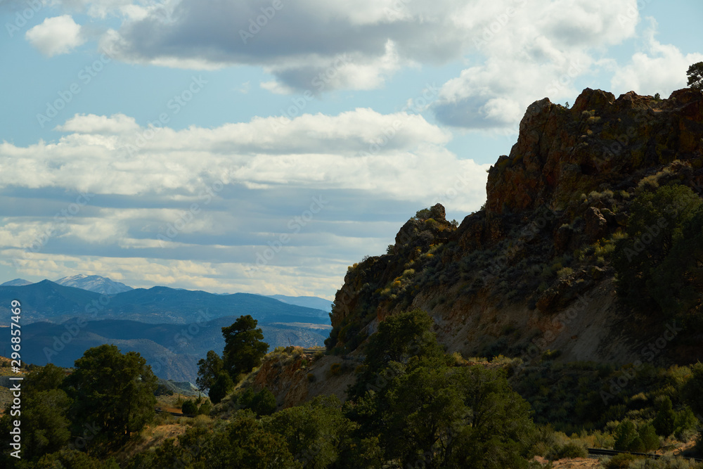 Naklejka premium Rocky Bluffs overlooking a Nevada canyon with mountains in the background