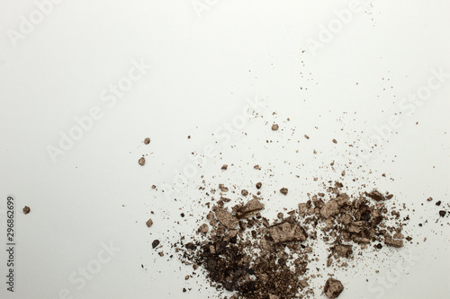 This is a photograph of a light Brown powder eyeshadow isolated on a White background