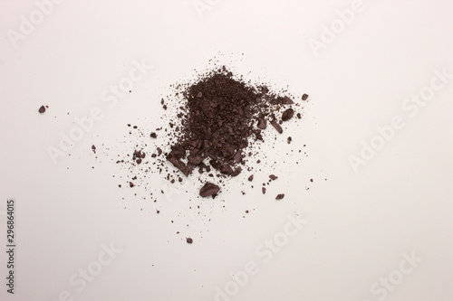 This is a photograph of a Dark Purple powder Eyeshadow isolated on a White background