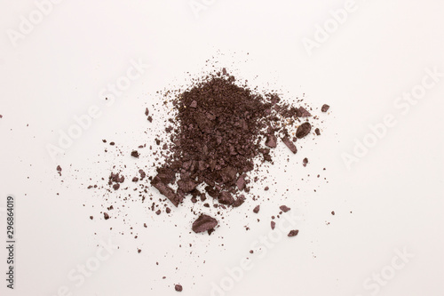 This is a photograph of a Dark Purple powder Eyeshadow isolated on a White background
