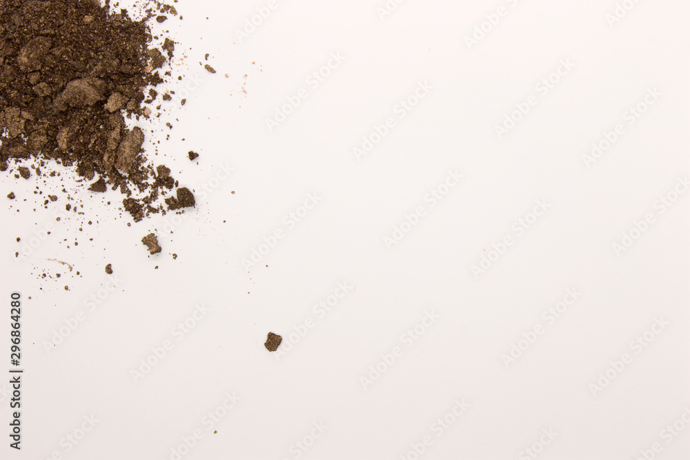 This is a photograph of a Dark Brown powder Eyeshadow isolated on a White background