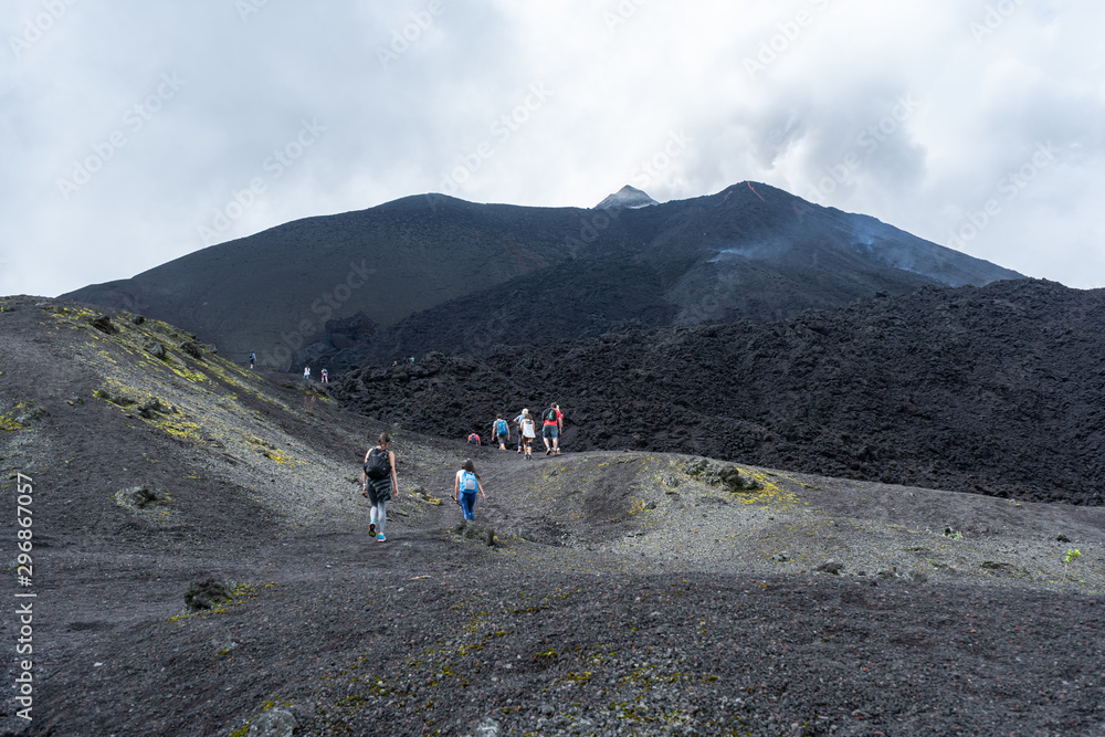 Men and women climb together to the top of the Pacaya volcano in Guatemala.