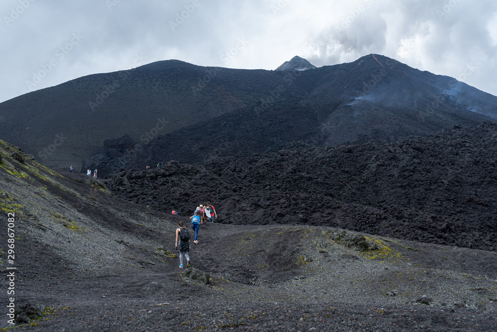 All hikers pass by the volcanic rocks of the Pacaya volcano in Guatemala.