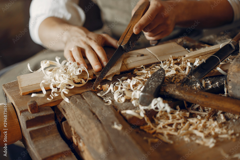 Man working with a wood. Carpenter in a white shirt Man working with a wood. Carpenter in a white shirt