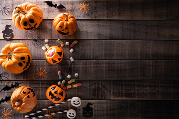 Top view of Halloween crafts, orange pumpkin, white ghost, bat and spider on dark wooden background with copy space for text. halloween concept.