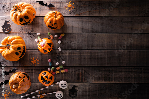 Top view of Halloween crafts, orange pumpkin, white ghost, bat and spider on dark wooden background with copy space for text. halloween concept.