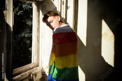 The struggle for their rights. Equality and freedom. Young attractive guy with a gay flag. © vladorlov