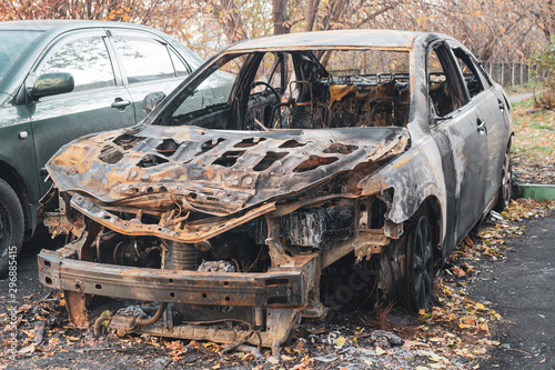 destroyed vehicle after a fire melted is on the street. people burned down the car of a man they hated