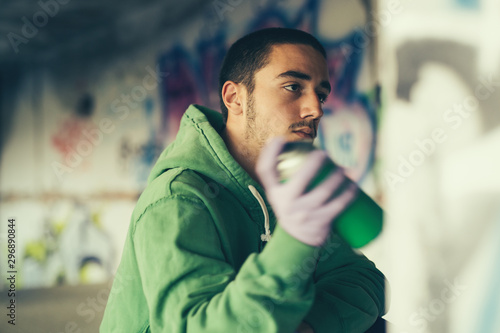 Street artist painting colorful graffiti on a wall.