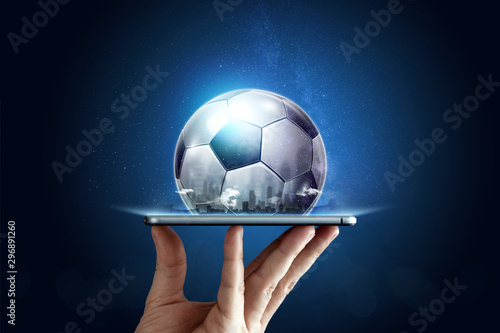Obraz na płótnie Smartphone in hand with a 3D soccer ball on a blue background