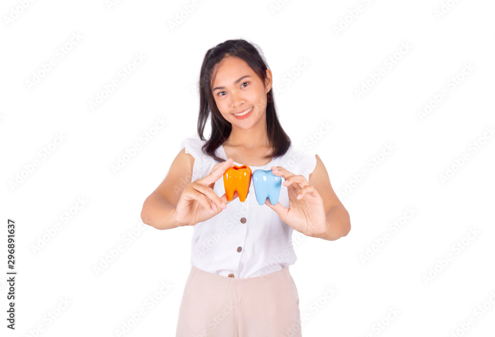 An Asian girl in white tank top and baige trunk holds ceramic tooth in her hands.