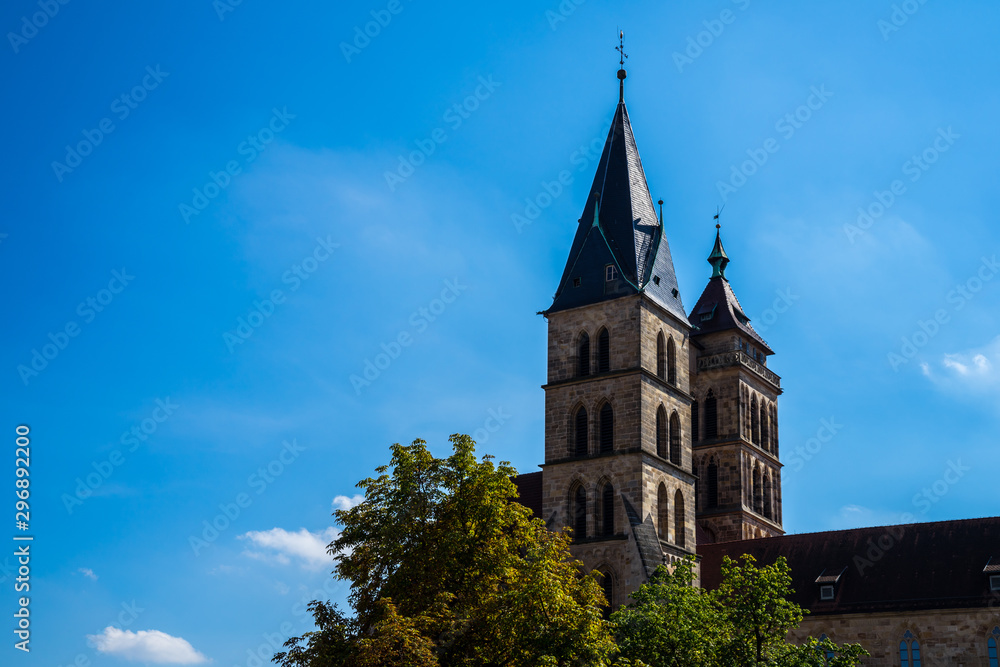 Germany, Medieval old historical dionys or dionysius church in downtown of city esslingen am neckar with two steeples connected by a bridge under blue sky