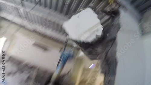 First person view of demolition work. A man is destroying a wall in flat with dust using hammer photo