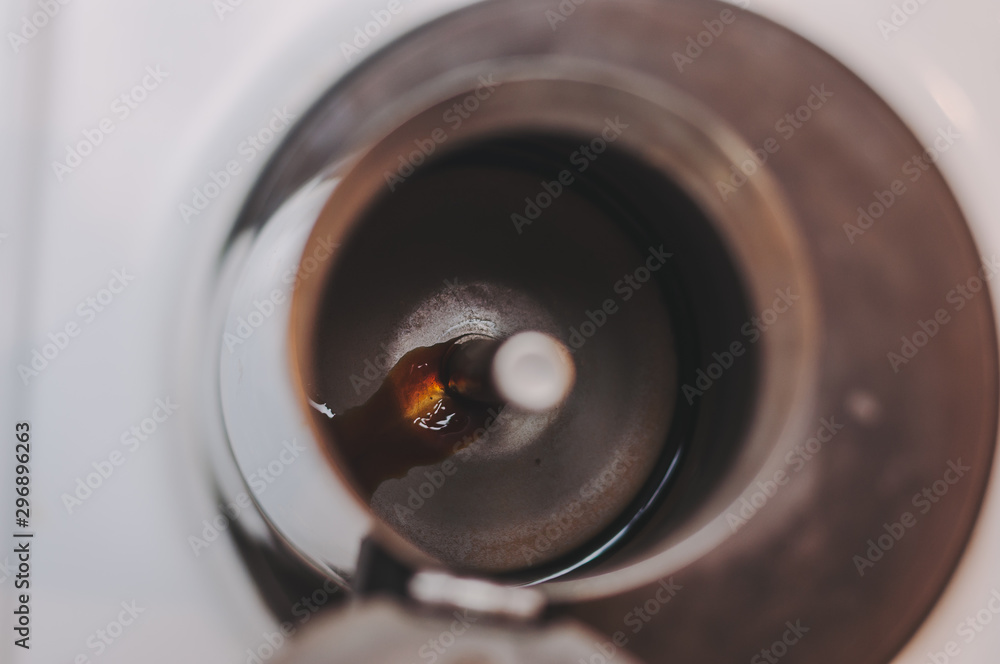 The first stream of fresh coffee flows from the spout of the coffee maker under pressure. The first stream of fresh coffee flows from the spout of the coffee maker under pressure.