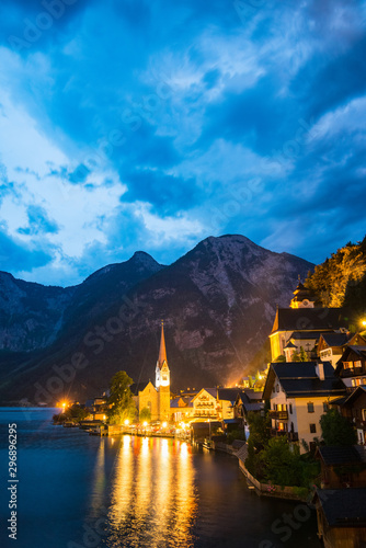 Scenic view of famous Hallstatt lakeside town reflecting in Hallstattersee lake in the Austrian Alps night time in summer, Salzkammergut region, Austria © naughtynut
