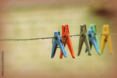 Plastic clothespins on wet wire after rain in the backyard close-up. Retro style
