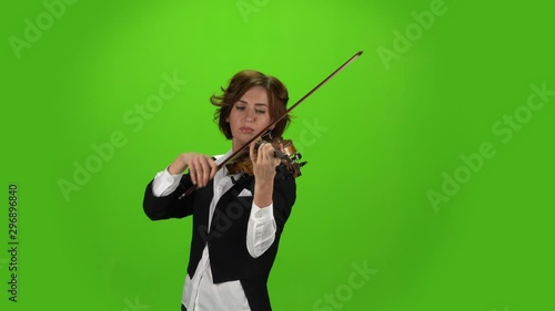 Girl in the jacket plays the violin . Green screen photo