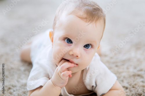 Cute Caucasian girl baby crawling on the carpet photo