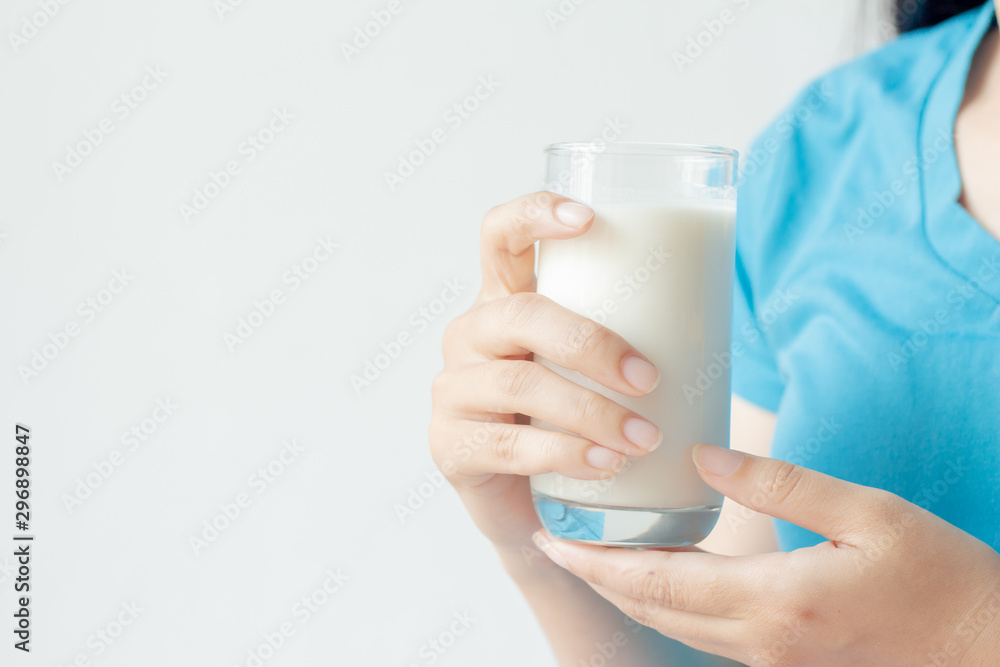 Woman hand holding glass of fresh milk on white background. Woman hand holding glass of fresh milk on white background.